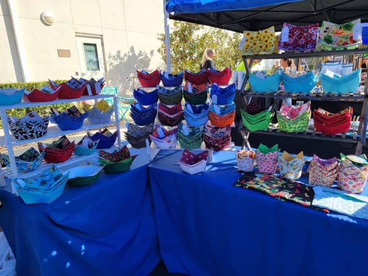 Market setup with bowl cozies on a blue table covering